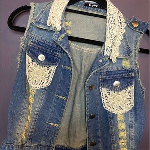 Fashionable medium blue jean vest with lace and pearls.